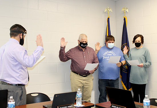 Eric Knutson (left) administers the oath of office to Jeryl Nelson, Lynn Junck and Jaime Manz during Monday's Wayne Community Schools' Board of Education meeting.