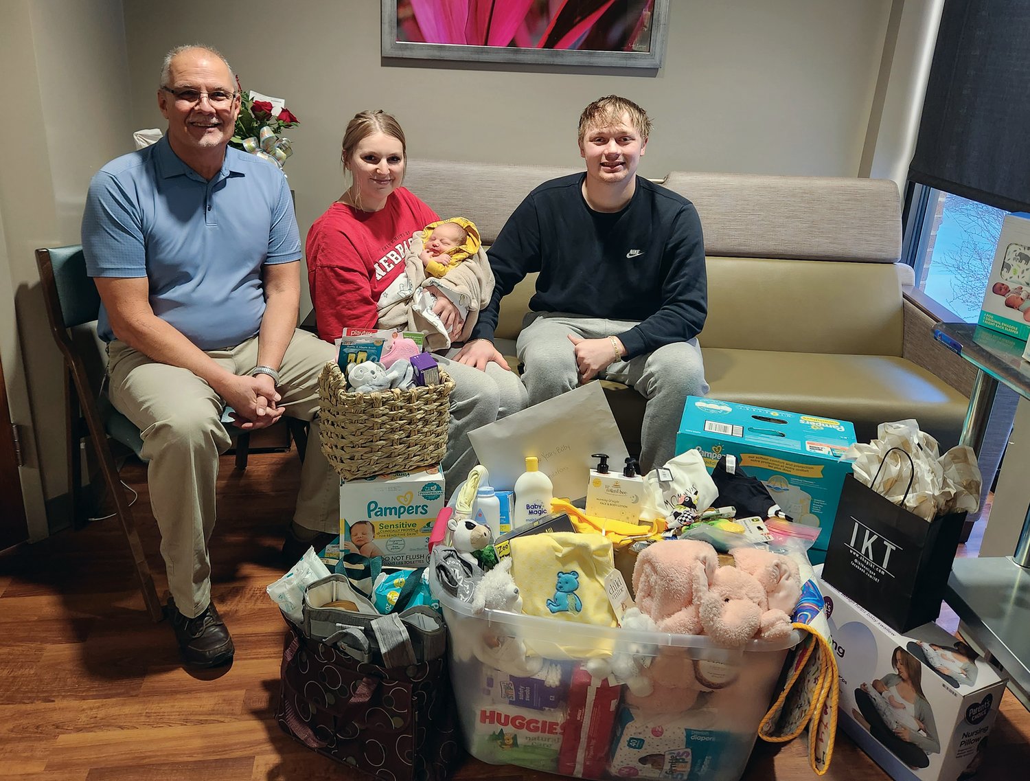 Dr. Benjamin Martin (left) poses with the PMC's New Year's Baby Finn Andrew Stoll and his parents. Also pictured are the items he received for being the first baby born at PMC in 2023.