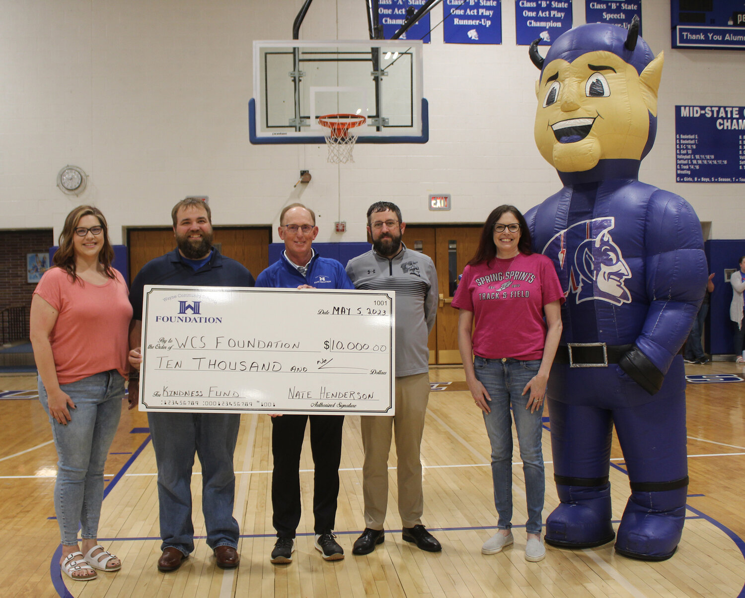 Involved in the presentation of a $10,000 check to the Wayne Community Schools Foundation were (left) Andrea Henderson, Nate Henderson, Rusty Park, Mike Varley, Misty Beair and Big Blue. The presentation was made prior to a pep rally at the school honoring those athletes taking part in this year's Spring Sprints. The money will go to the Wayne Schools' Kindness Fund.